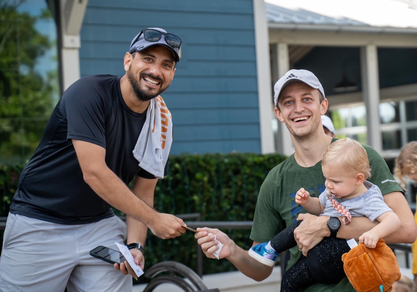 Pablo giving a finisher card to a dad and baby